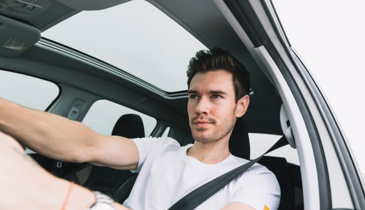 Confident man driving car with focus.