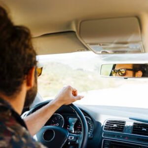 Young male driver enjoying sunny day drive after passing road test